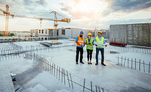 3 construction workers on a building under construction for a lerge project