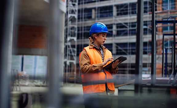 women on construction site entering data into tablet